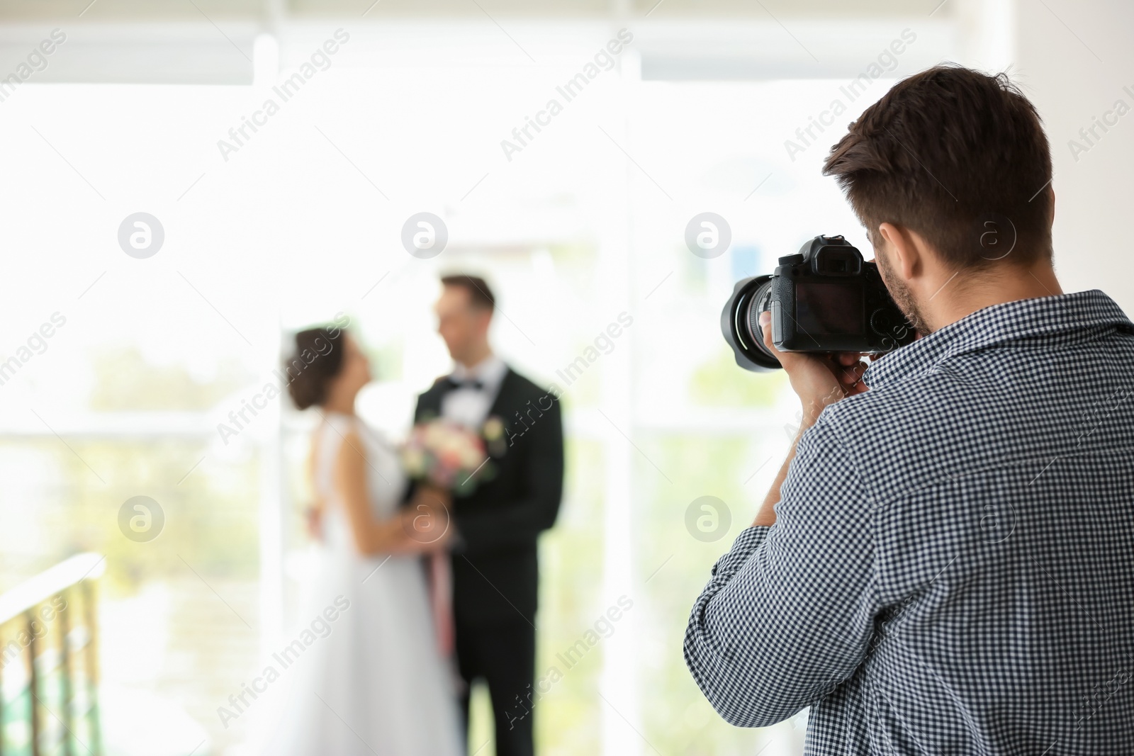 Photo of Professional photographer taking photo of wedding couple in studio