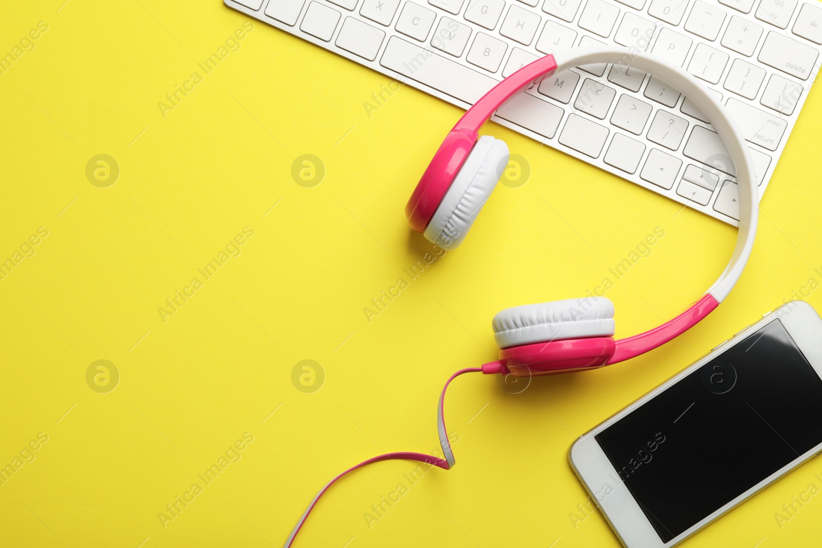 Photo of Modern headphones, keyboard and phone on color background, flat lay. Space for text