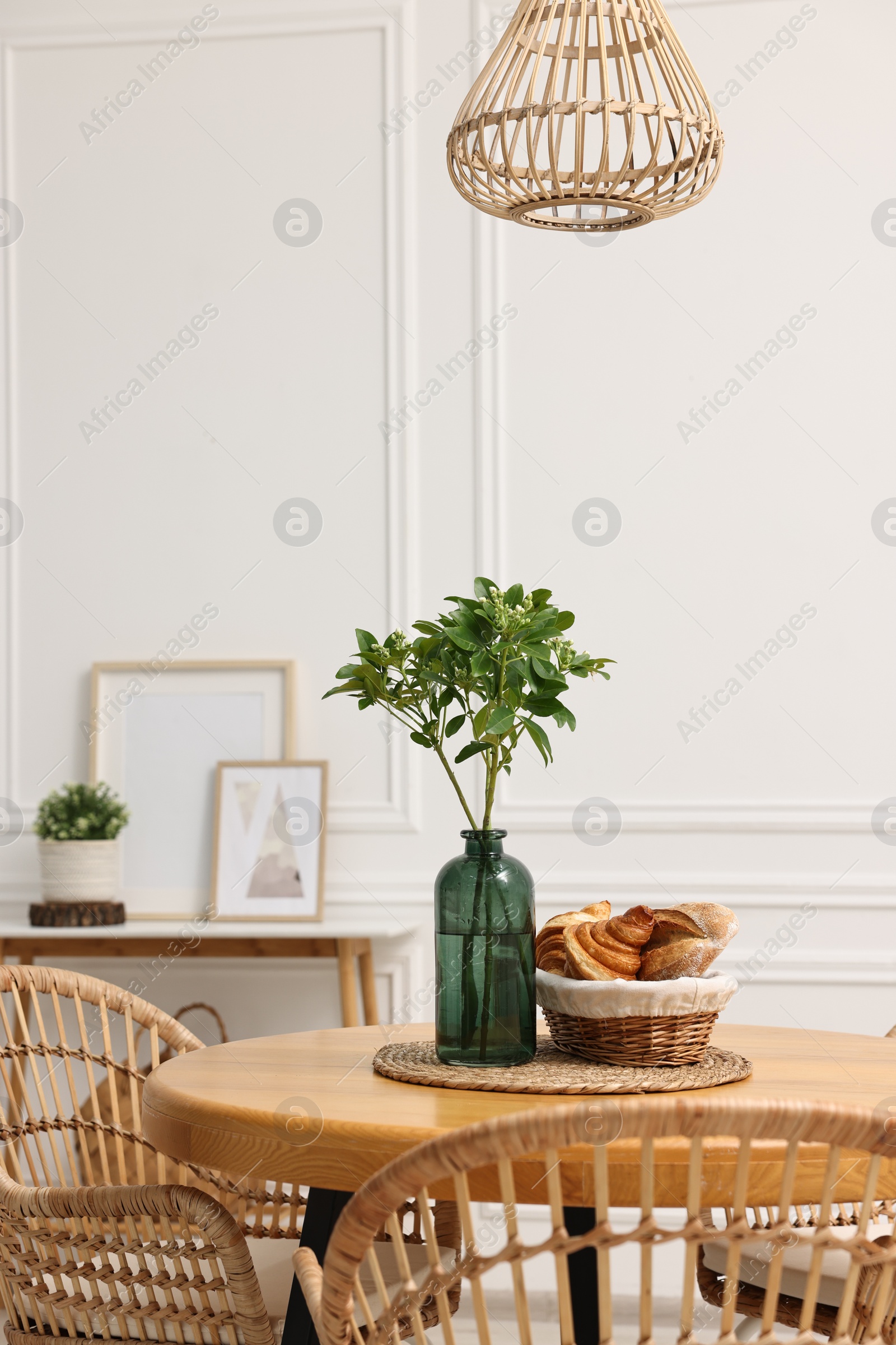 Photo of Dining room interior with comfortable furniture and green branches