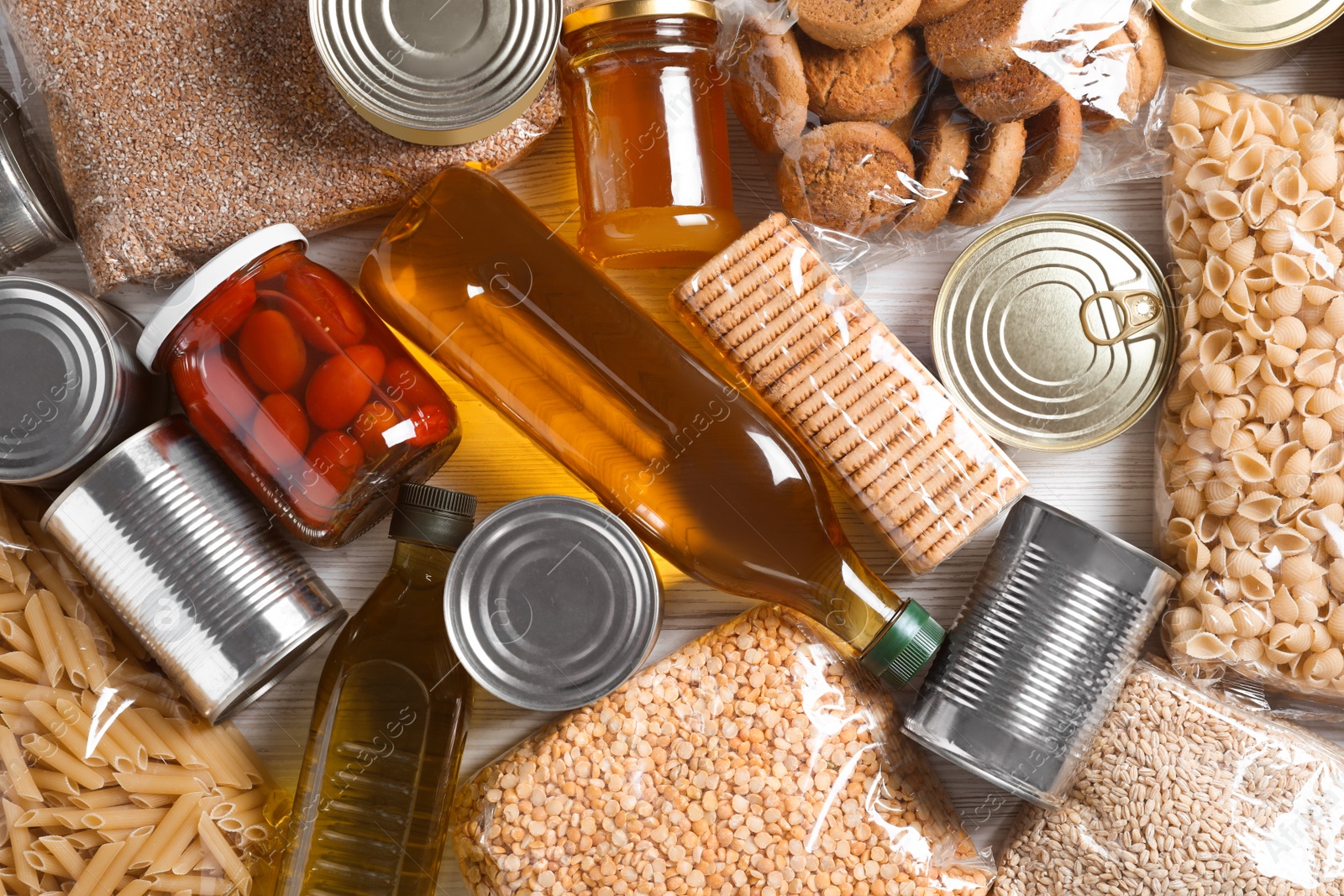 Photo of Different products on white wooden table, flat lay. Food donation