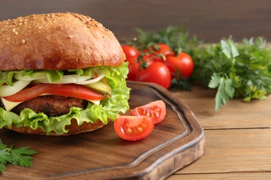 Photo of Delicious vegetarian burger served on wooden table, closeup