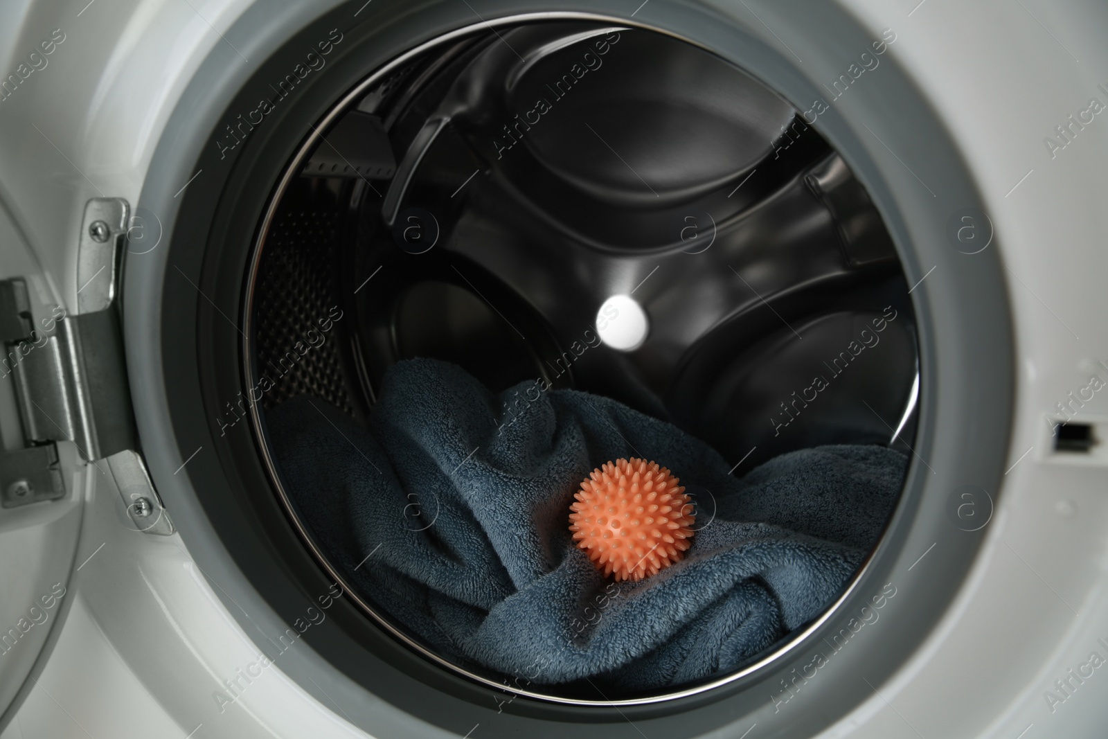 Photo of Dryer ball and towel in washing machine, closeup