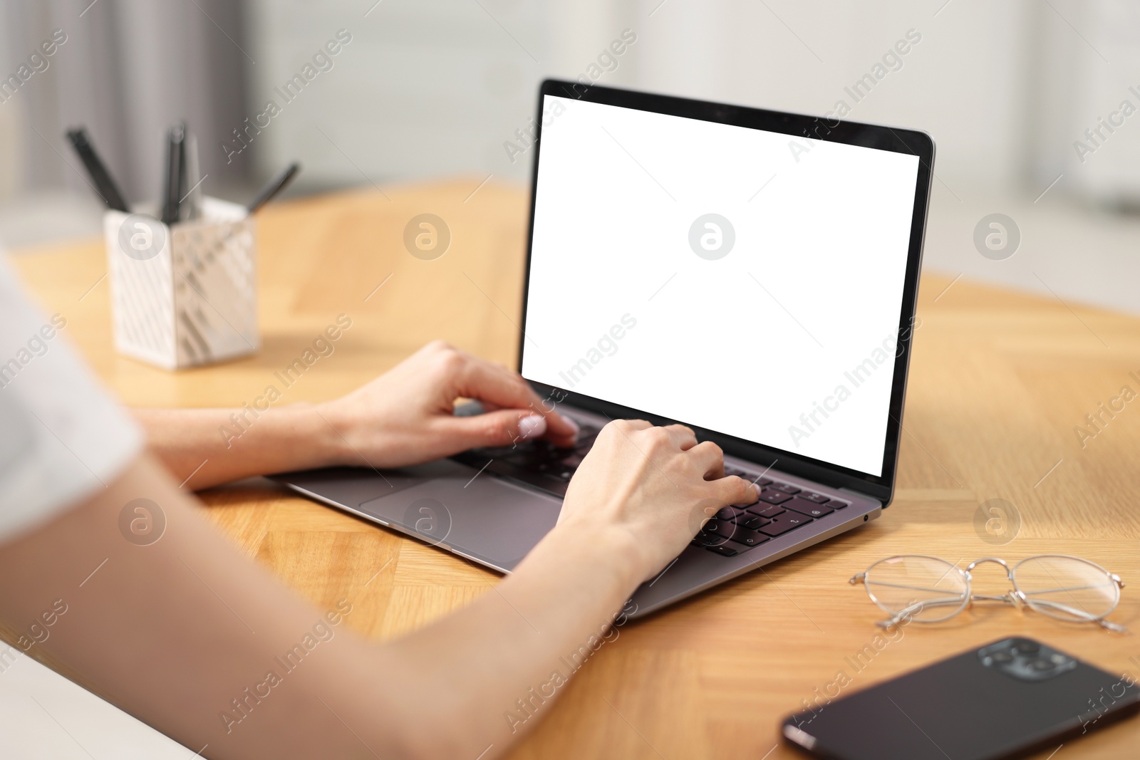 Photo of Young woman watching webinar at table indoors, closeup