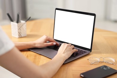 Photo of Young woman watching webinar at table indoors, closeup