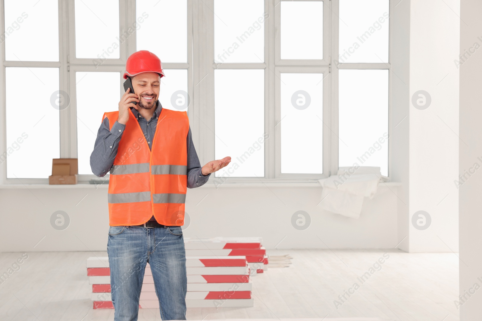 Photo of Male industrial engineer in uniform talking on phone indoors