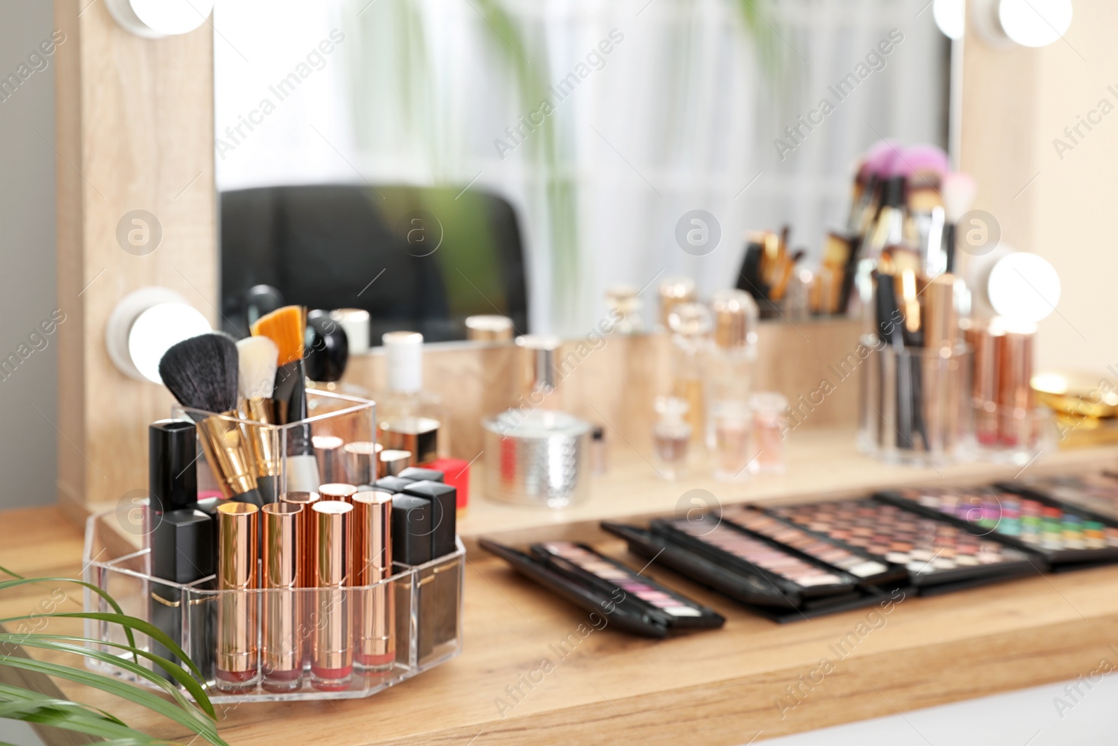 Photo of Set of luxury makeup products on dressing table with mirror. Space for text