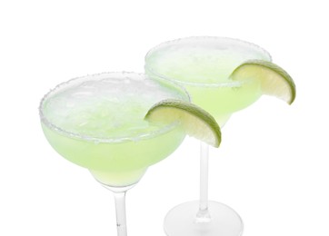 Photo of Delicious Margarita cocktail with ice cubes in glasses, salt and lime isolated on white