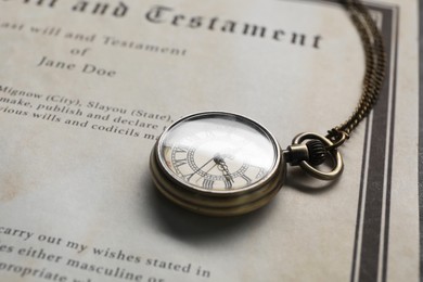 Photo of Last Will and Testament with pocket watch, closeup