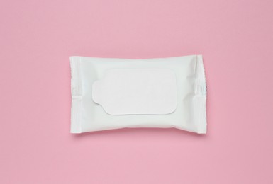 Photo of Wet wipes flow pack on pink background, top view