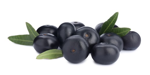 Pile of fresh ripe acai berries and green leaves on white background