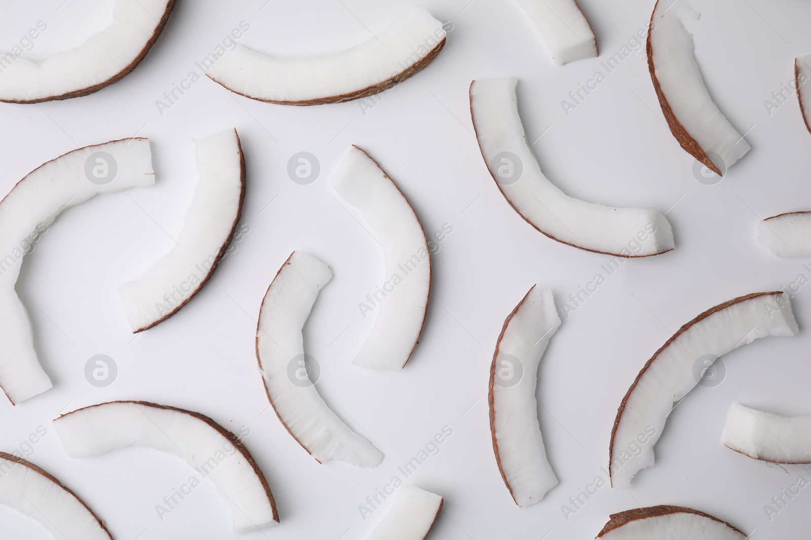 Photo of Pieces of fresh coconut on white background, top view