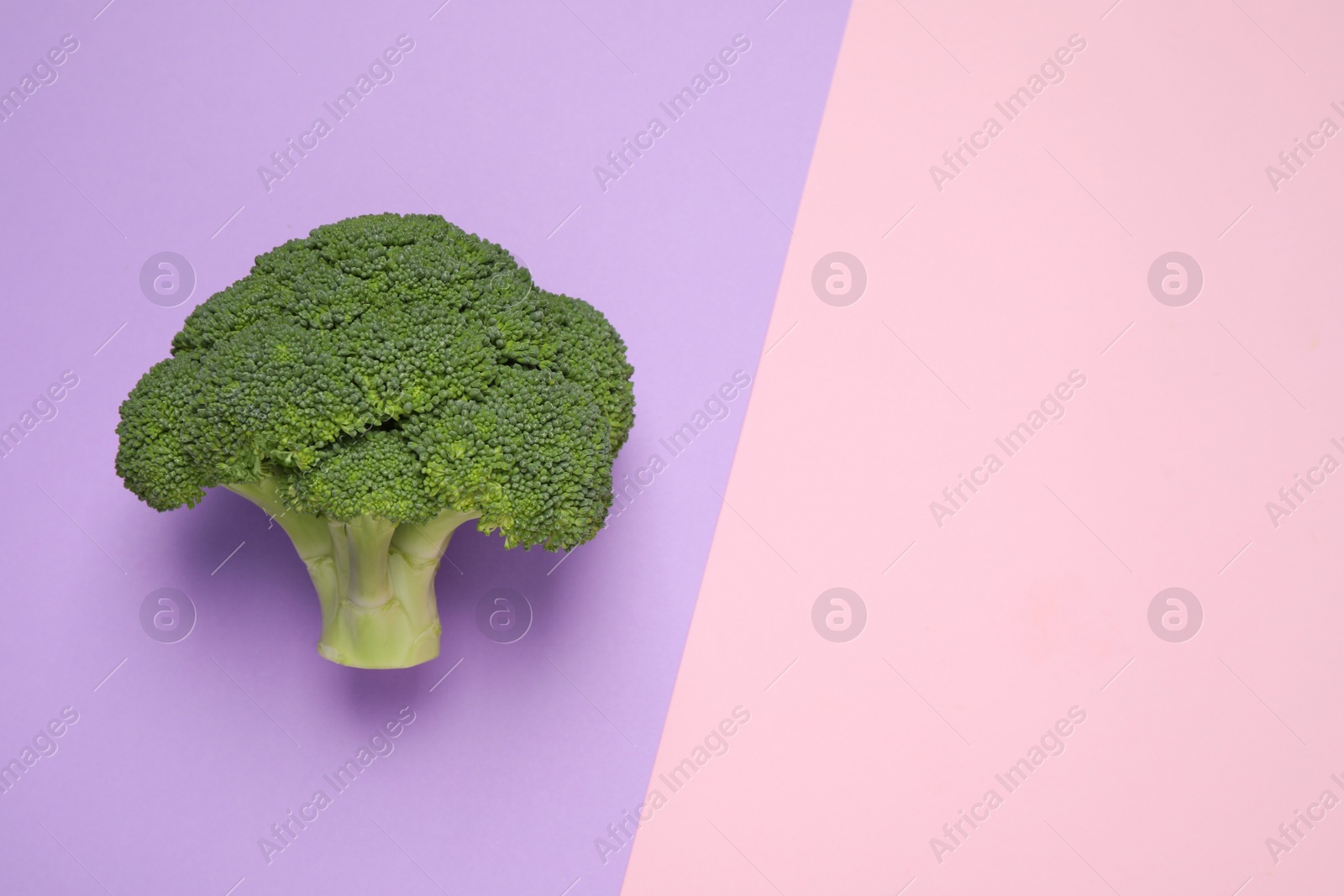 Photo of Fresh tasty broccoli on color background, top view. Space for text