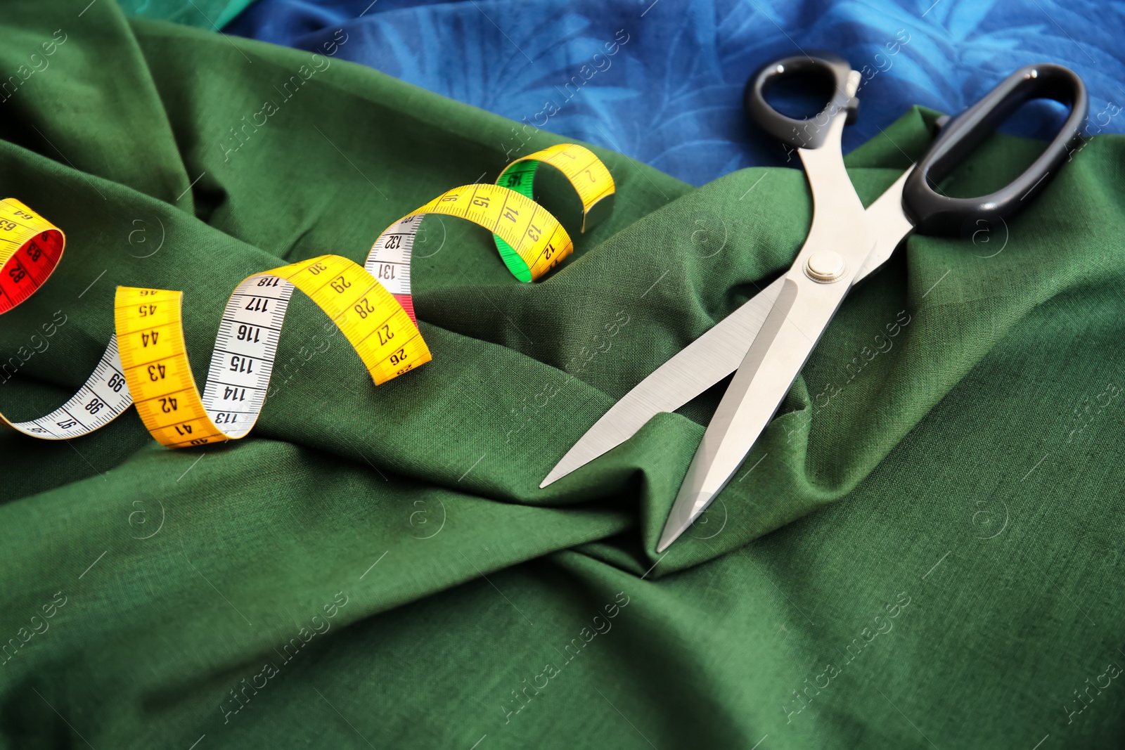 Photo of Scissors and measuring tape for tailoring on fabrics