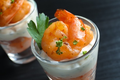 Photo of Glasses with fried shrimps and sauce on wooden background