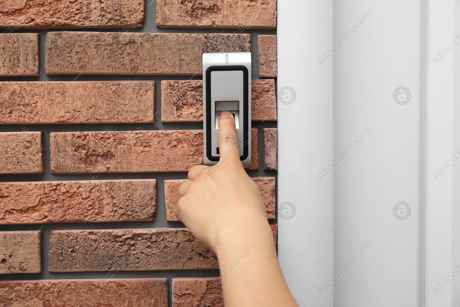 Photo of Young man scanning fingerprint on alarm system indoors