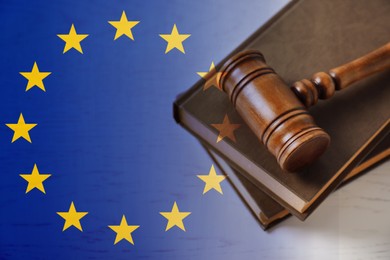 Image of Double exposure of European union flag and books with wooden gavel on white table