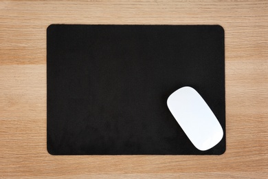 Photo of Blank pad and wireless computer mouse on wooden background, top view