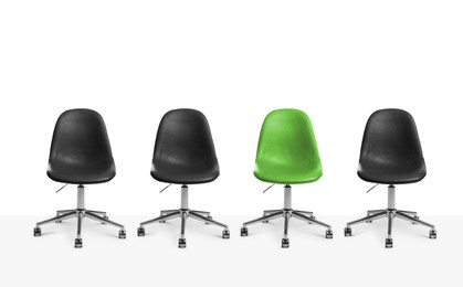 Image of Vacant position. Green office chair among black ones on white background