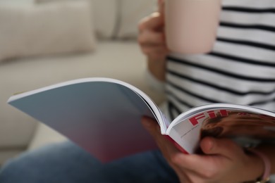 Photo of Woman reading sports magazine indoors, closeup view