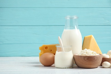 Different dairy products on white table against blue background. Space for text