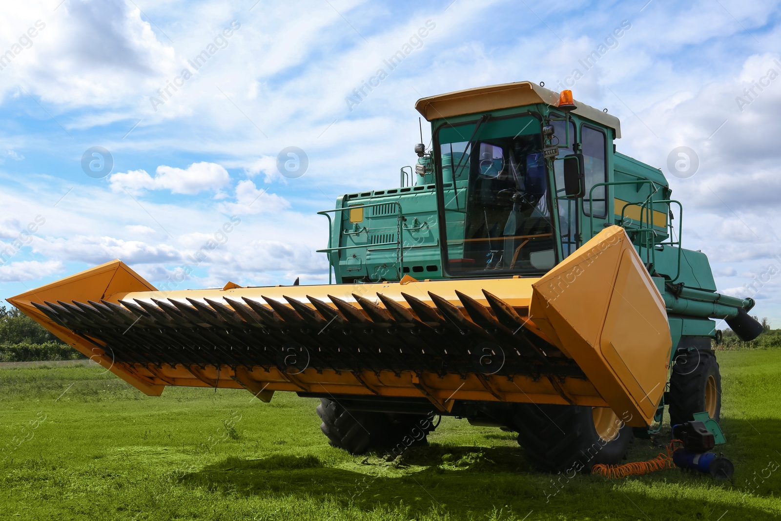 Photo of Modern combine harvester on green lawn with fresh grass