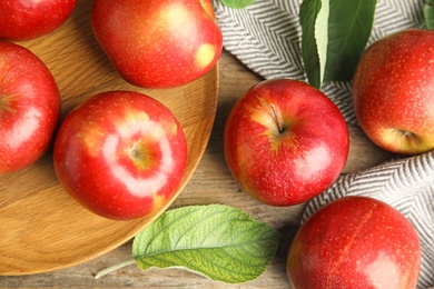 Photo of Ripe juicy red apples on wooden background, flat lay