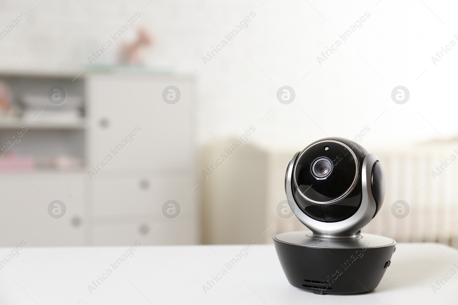 Photo of Baby camera on table in room, space for text. Video nanny