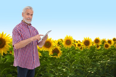 Farmer with tablet computer in field. Harvesting season