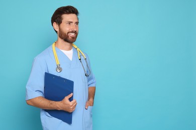 Photo of Happy doctor with stethoscope and clipboard on light blue background. Space for text