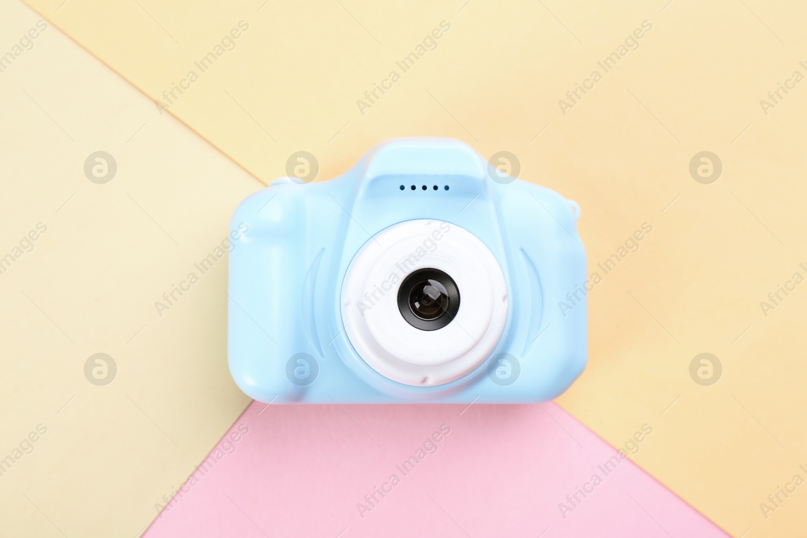 Photo of Light blue toy camera on color background, top view