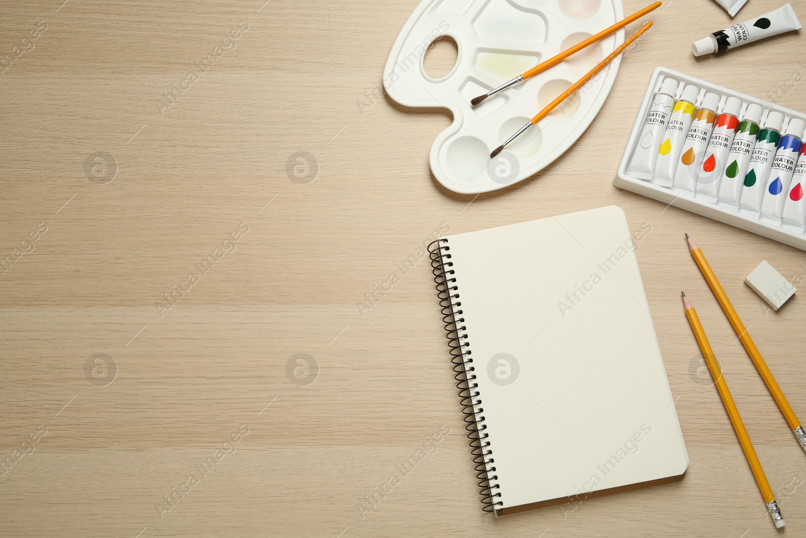 Photo of Flat lay composition with blank sketchbook on wooden table. Space for text