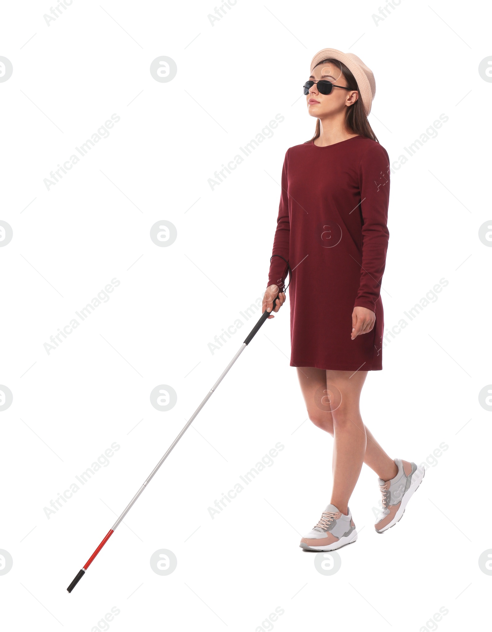 Photo of Young blind person with long cane walking on white background