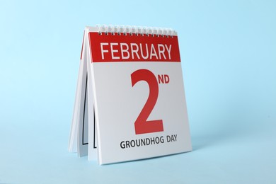 Photo of Calendar with date February 2nd on light blue background. Groundhog day