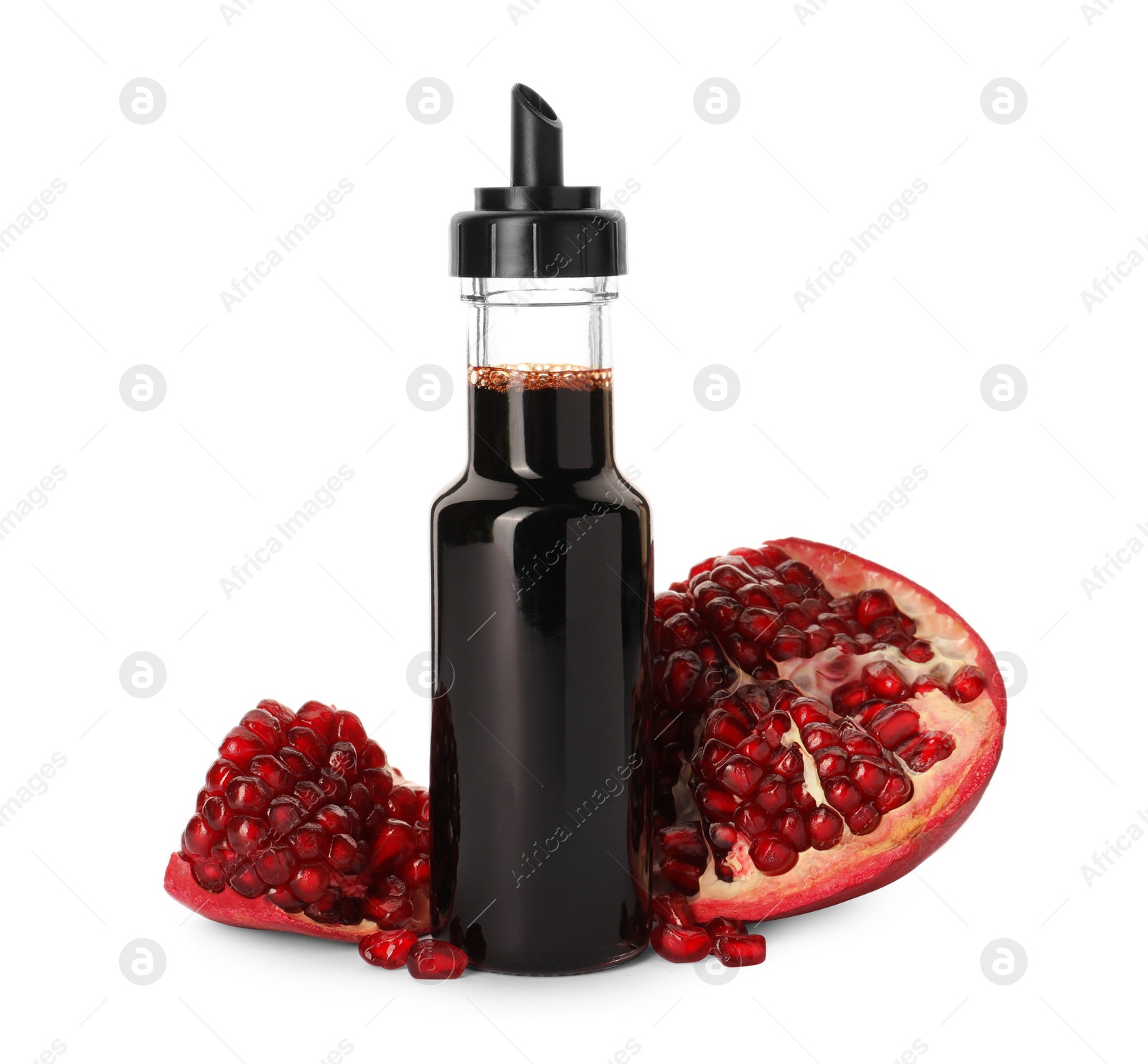 Photo of Bottle of pomegranate sauce and fresh ripe fruit on white background