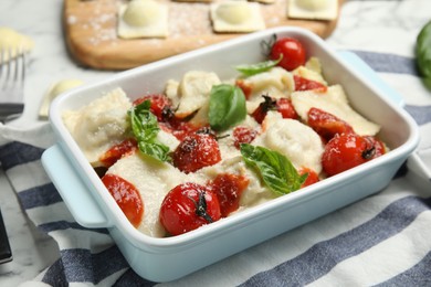 Photo of Tasty ravioli with tomato sauce on white marble table