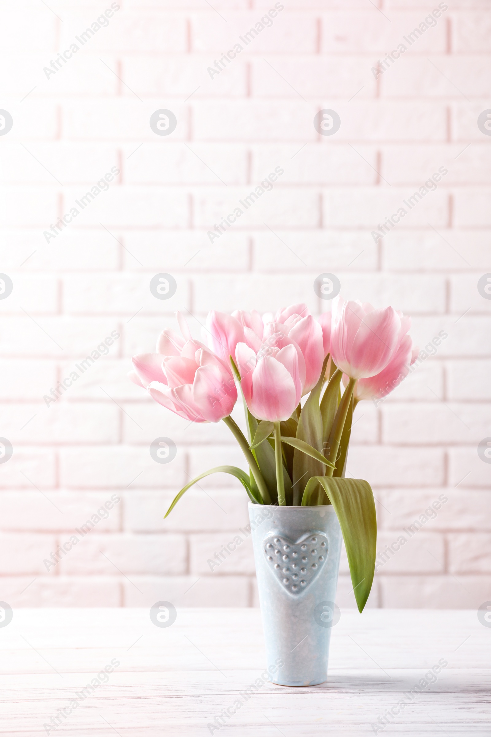 Photo of Vase with beautiful tulips for Mother's Day on table