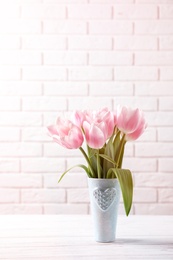 Photo of Vase with beautiful tulips for Mother's Day on table