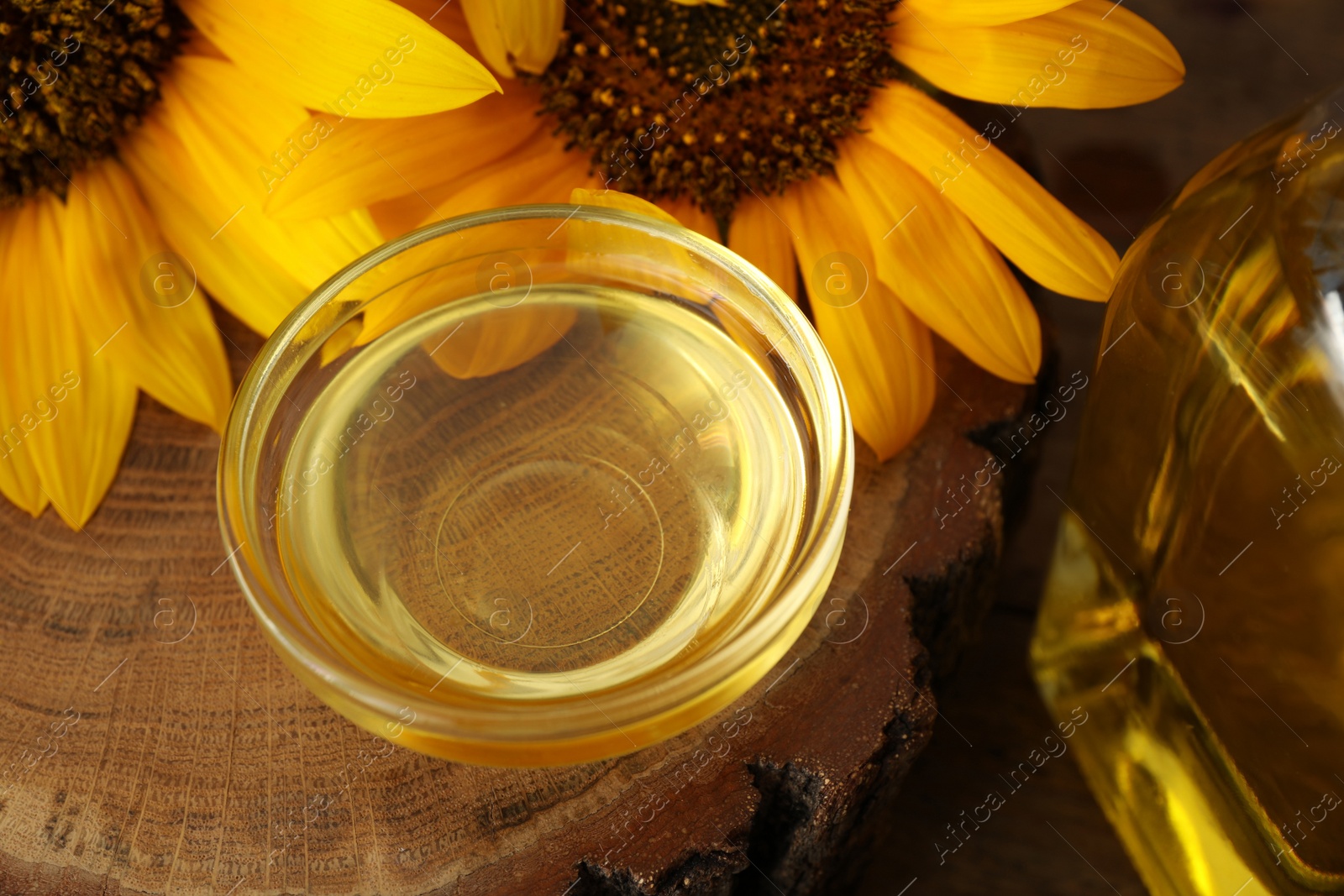 Photo of Sunflowers and oil on wooden board, closeup