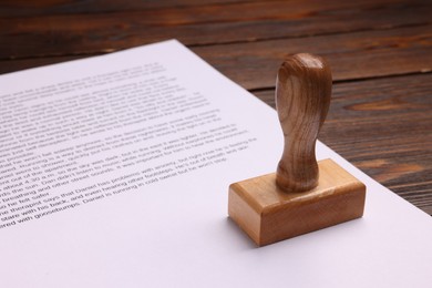 One stamp tool and document on wooden table, closeup