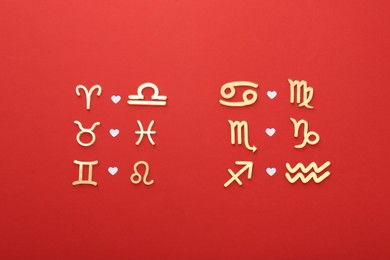 Photo of Zodiac signs compatibility on red background, flat lay
