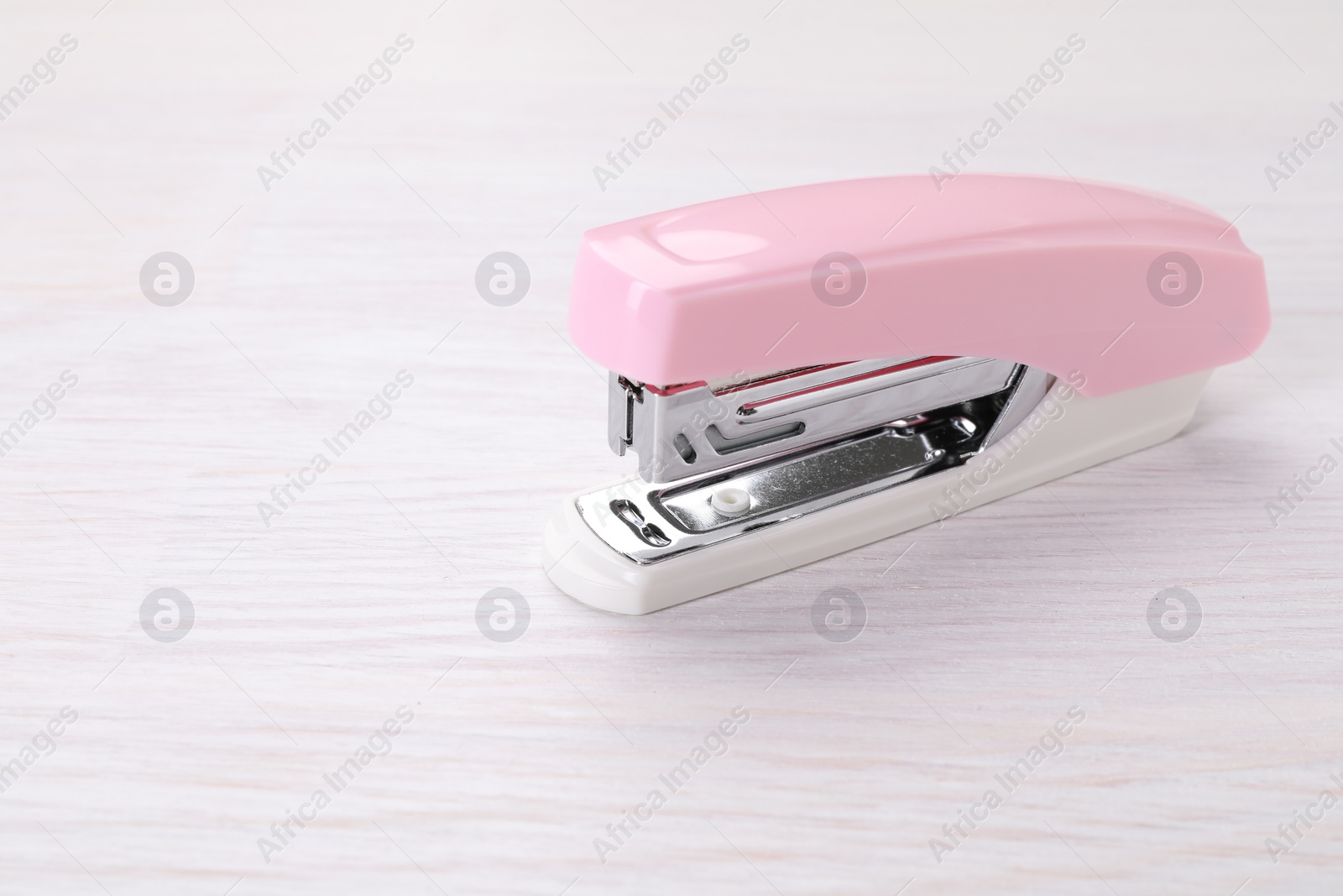 Photo of Stapler on light wooden table, space for text