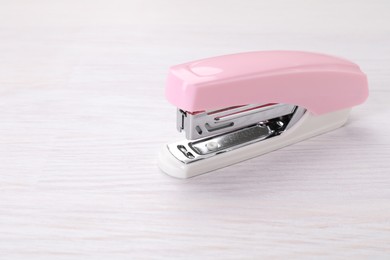 Photo of Stapler on light wooden table, space for text