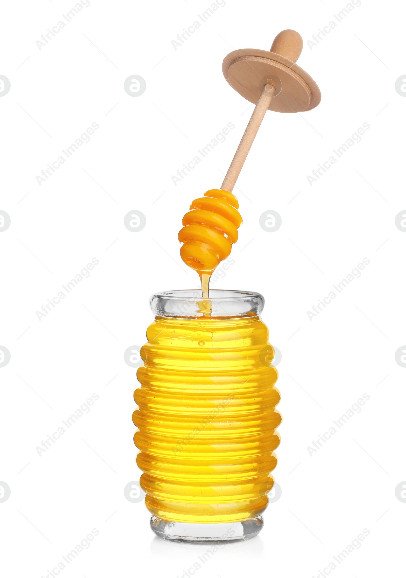 Photo of Honey dripping from dipper into jar isolated on white