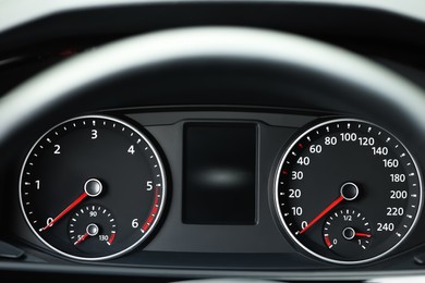 Speedometer on car dashboard, view through steering wheel