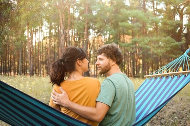 Lovely couple resting in comfortable hammock outdoors, back view