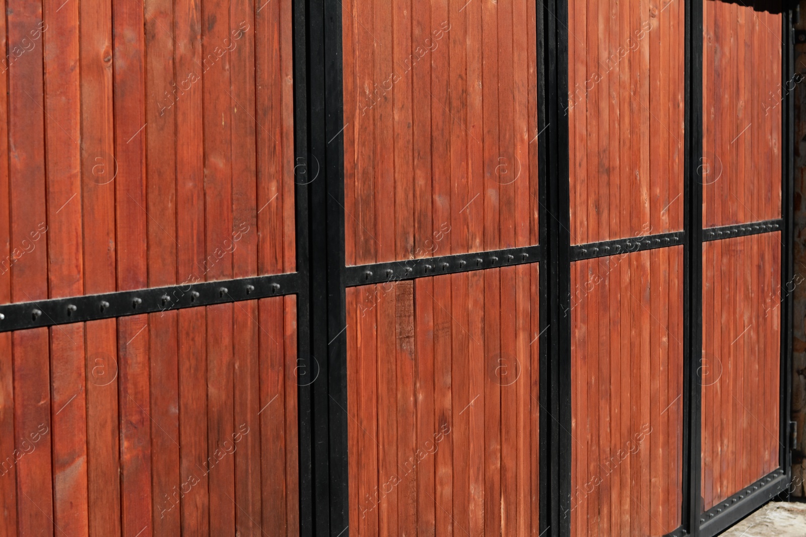 Photo of Metal and wooden fence outdoors on sunny day