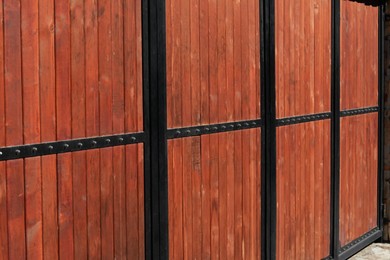 Metal and wooden fence outdoors on sunny day