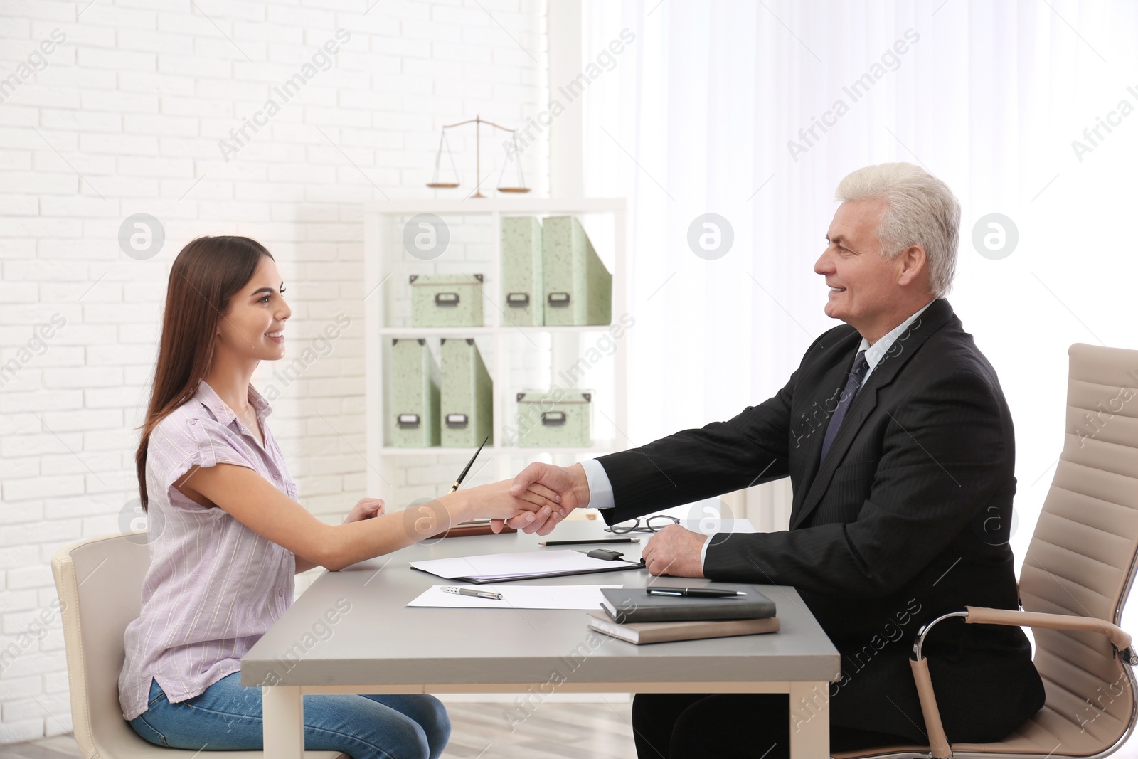 Photo of Young woman having meeting with lawyer in office