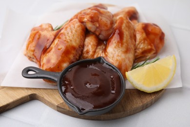 Raw chicken wings, lemon and marinade on light table, closeup