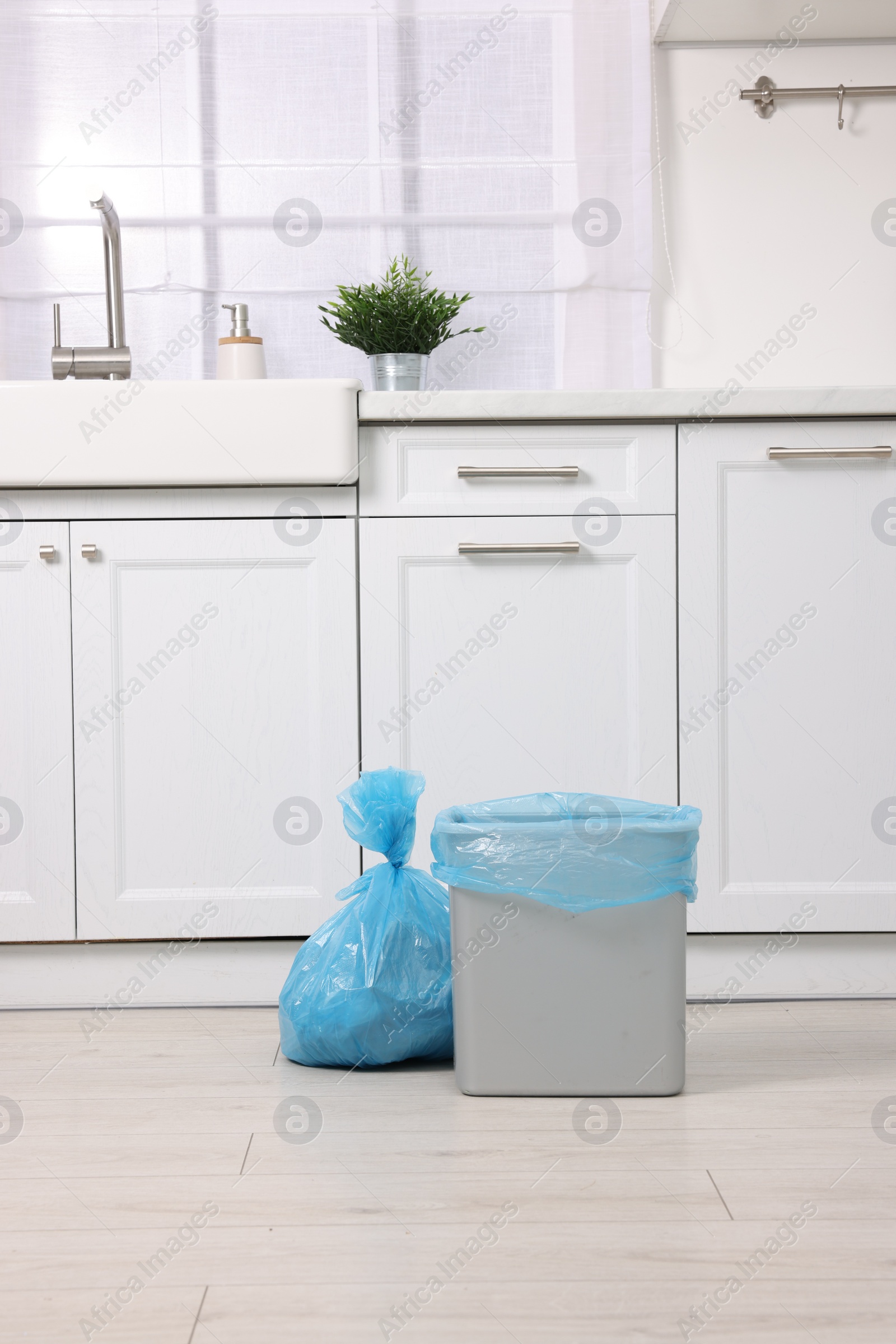 Photo of Plastic garbage bag and trash can in kitchen